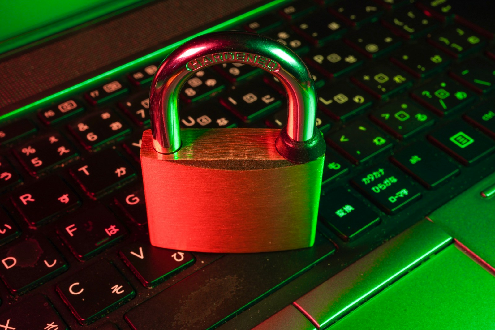 Vorhängeschloss auf einer Kreditkarte neben einer Laptop-Tastatur als Symbol für sicheres Bezahlen im Internet