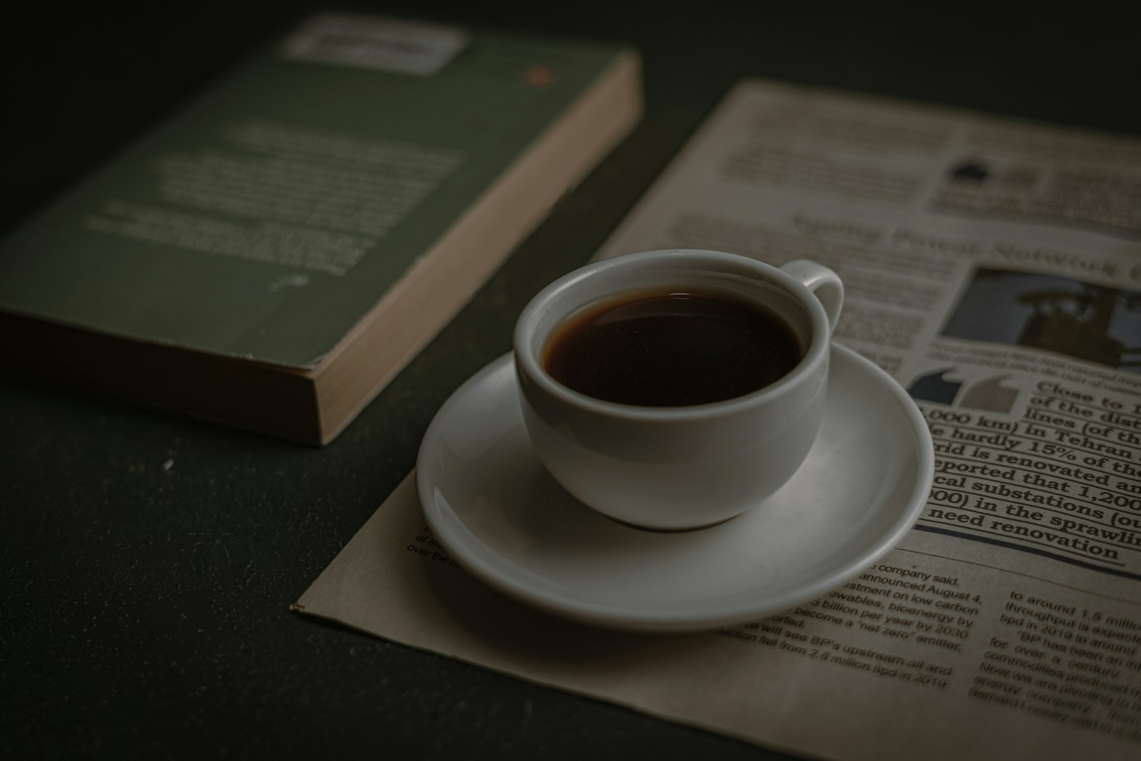 Morgenkaffee neben einer gefalteten Zeitung auf einem Frühstückstisch